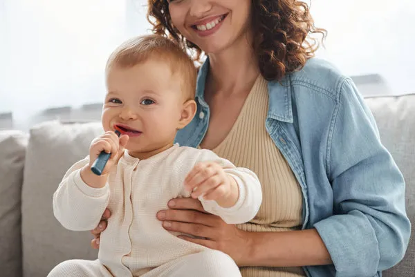 Why Do Babies Drool When Teething? A Comprehensive Guide for Parents Little Girl Chewing Teething Toy Smiling