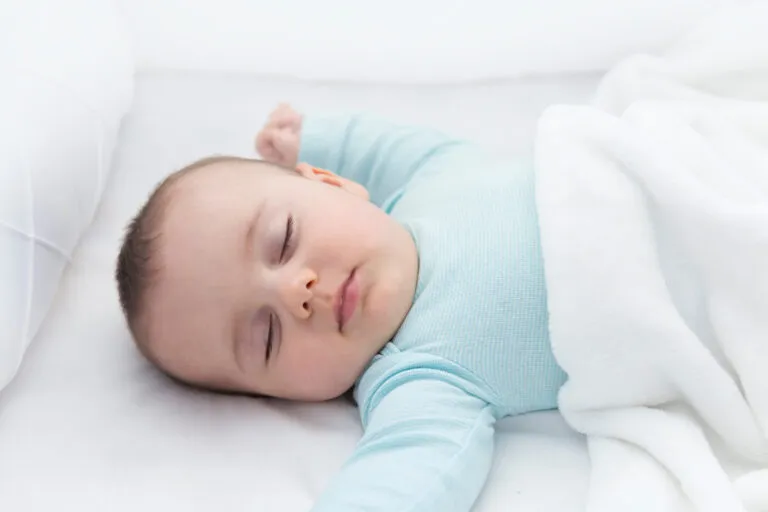 When Can A Baby Sleep With A Blanket: A Comprehensive Guide To Safe Infant Sleep A baby sleeps peacefully in a bare crib, demonstrating a safe sleep environment.